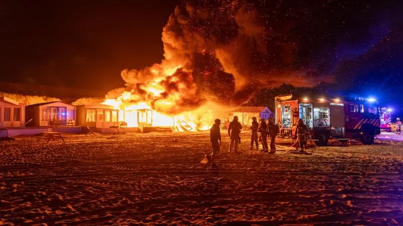 Gewonde bij grote uitslaande brand op strand bij Wijk aan Zee, zes strandhuisjes verwoest
